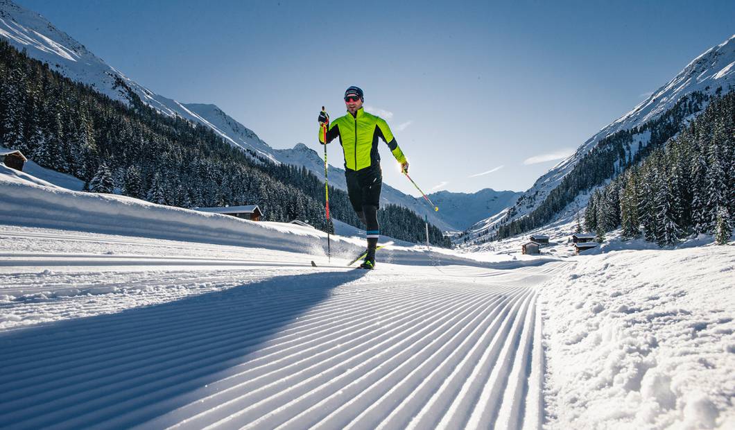 Langlaufen im Winterurlaub - Person beim Loipe laufen